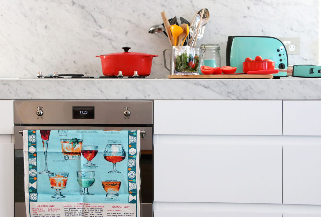 white kitchen cabinet with green appliances and red pot on stove to add color to kitchen