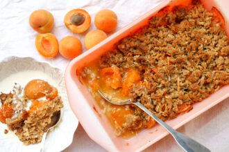 apricot crumble in a dish with fresh apricots