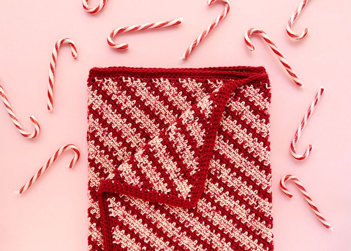 red and pink diagonal stripe blanket with candy canes