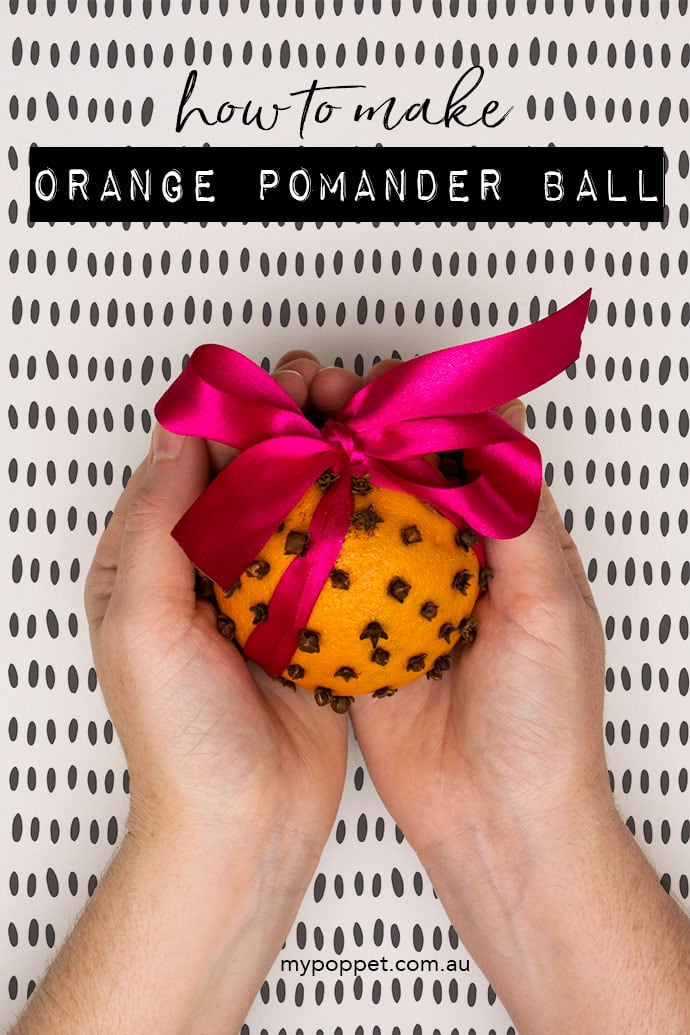 Hands holding orange pomander