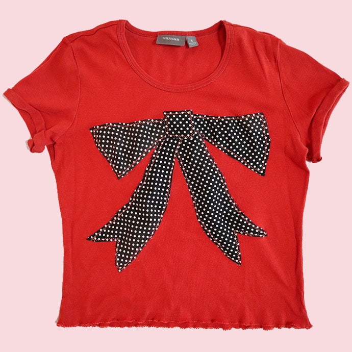 Orange t-shirt with black applique bow design 