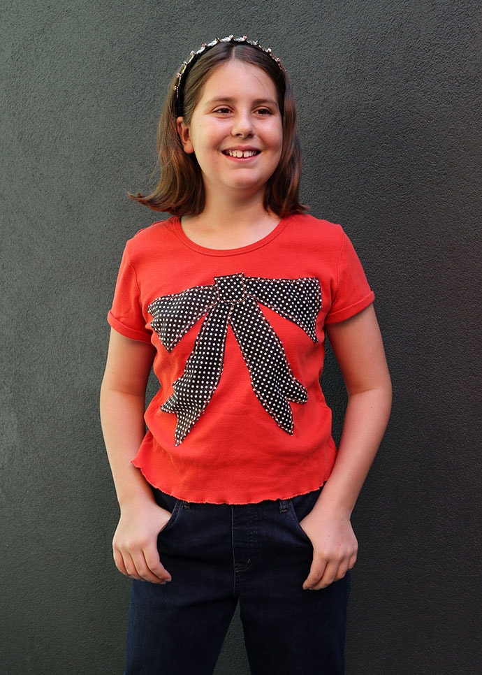 t shirt refashion idea - girl wearing and orange tshirt with large bow applique