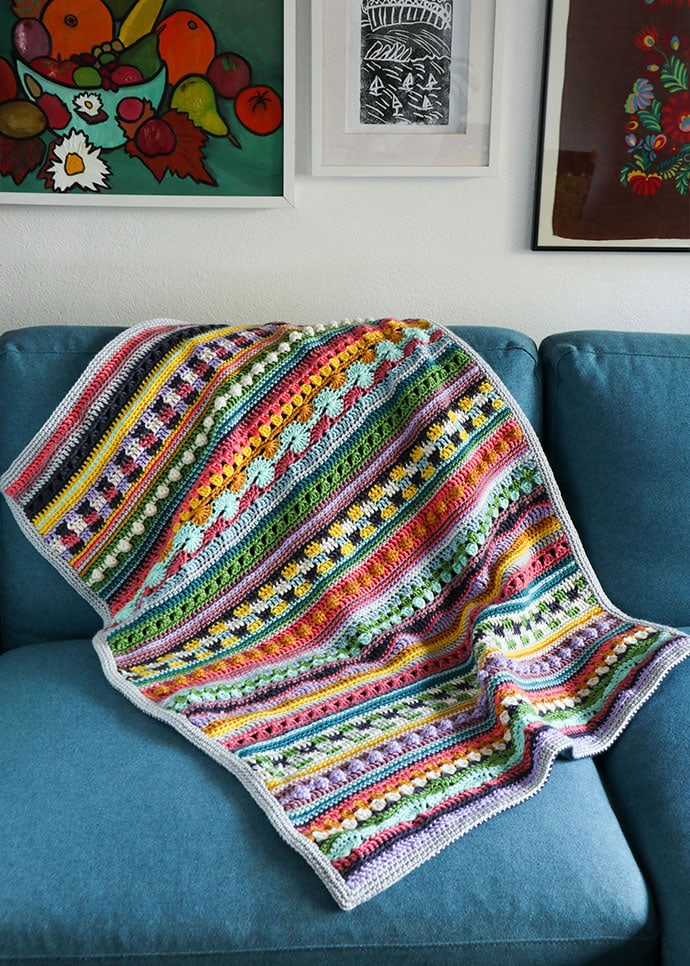 Crochet sampler blanket on a blue sofa