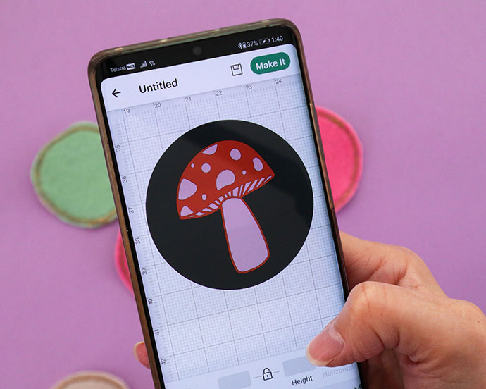 hand holding phone with mushroom design on cricut design space