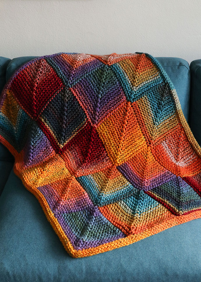 mitered squares baby blanket made from premier colorfusion yarn thrown over sofa