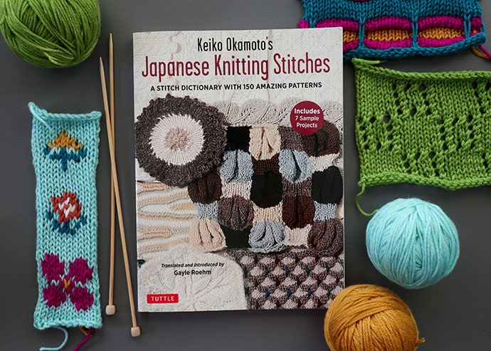 japanese knitting stitches book surrounded by knitting samples and balls of yarn